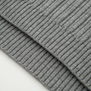 Detailed close-up of grey loose off-shoulder knit sweater showing rib-knit texture