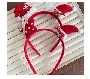 Close-up of Christmas headbands with red plush, mini hats, bells, and snowflakes