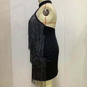 Detail of black mini dress featuring shimmering silver fringe tassels on sewing mannequin