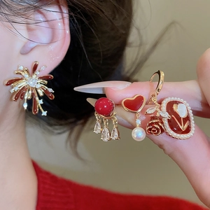 Detailed view of red enamel and pearl earrings set with vintage fireworks motifs