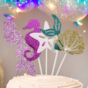 Close-up of glittery mermaid tail, seahorse, and starfish toppers for party cakes