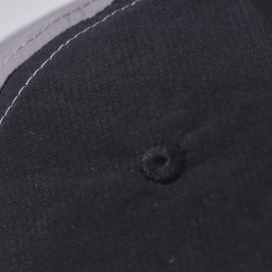 Macro shot of cotton baseball cap fabric with reinforced stitching and embroidered eyelet