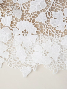 Détail de dentelle florale blanche avec doublure nude et texture au crochet