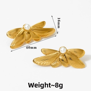 Detailed view of golden butterfly earrings with 40mm length and pearl center
