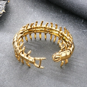Detailed macro view of a gold-toned stainless steel centipede cuff bracelet design