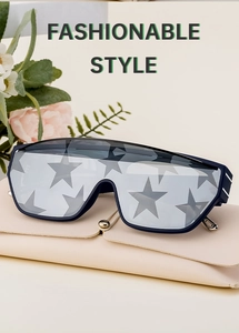 Detail of navy blue square sunglasses with star pattern lens on a cream leather case