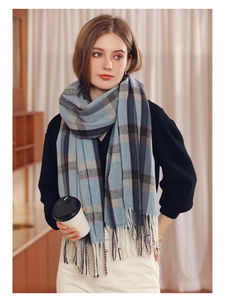 Detailed view of the soft cashmere-like texture and fringed edges of a blue plaid scarf