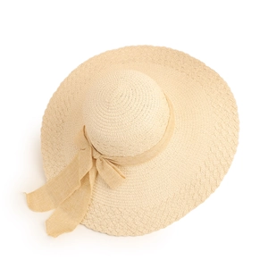 Detail of beige straw hat with wide brim, ribbon bow and natural woven texture