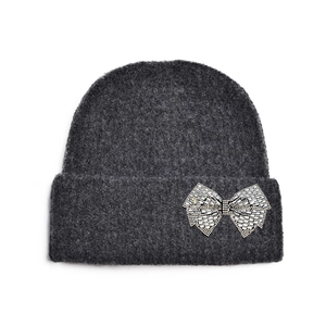 Détail du bonnet en maille gris foncé orné d'un nœud étincelant en strass argentés