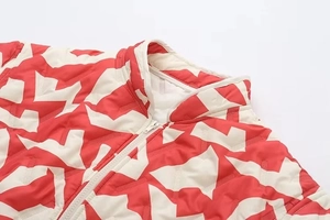 Détails de la veste matelassée rouge et blanche à motif géométrique et col montant