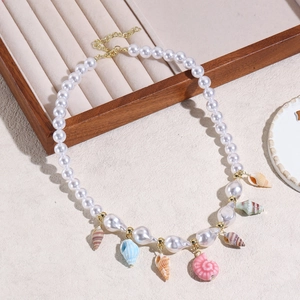 Detail view of multi-layer baroque pearl necklace with colorful seashell pendants