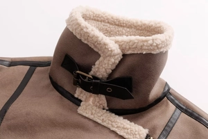 Close-up detail of vintage brown suede jacket with faux shearling collar and leather buckle