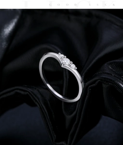 Macro shot of silver ring with three sparkling zircons on premium black leather