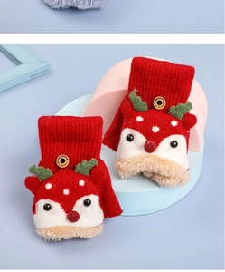 Detail of red knitted winter gloves featuring reindeer design and warm plush lining
