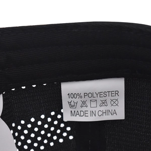 Detail shot of the 100% polyester fabric care label and washing instructions on a black cap