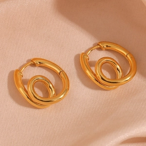 Makro-Detail von 18K vergoldeten Bambus-Creolen auf rosa Satin-Hintergrund für Damen