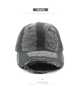 Detail view of charcoal grey distressed baseball cap showing frayed brim and vintage worn fabric