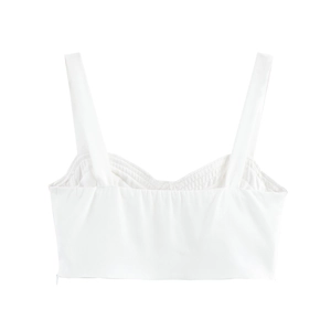Détail d'un crop top blanc au design minimaliste avec fermeture éclair invisible au dos