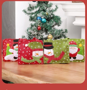 Detailed view of red and green Christmas felt gift bags with embroidered snowman and Santa