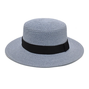 Detail of blue boater straw hat with black ribbon and spiral woven texture