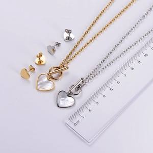 Detailed view of heart-shaped shell jewelry set with scale ruler for size measurement