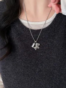 Detail of silver horse pendant with pavé zircons and Good Luck engraved tag on a necklace