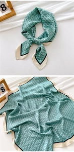 Detail of teal silk square scarf featuring chain link patterns and elegant beige borders