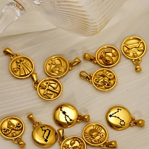 18K gold plated stainless steel 12 zodiac pendants on a textured beige fabric background