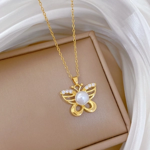 Detailed close-up of butterfly pendant with pearl body and crystal wings on gold chain
