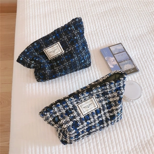 Detail of tweed makeup bags with woven texture and Time To Party label closure