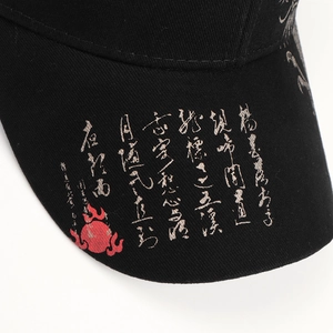 Close-up of black cotton baseball cap brim with gold Chinese calligraphy and red flame logo