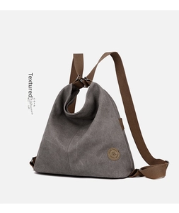 Dettaglio della borsa in tela grigia vintage con logo in pelle marrone classica