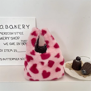 Détail du sac à main en peluche avec motif cœur rose et rouge avec doublure à carreaux
