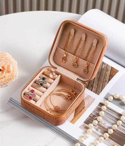 Close-up of vintage brown leather jewelry box with necklace hooks and ring storage