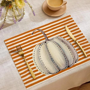Autumn placemat with orange stripes and white pumpkin design for Thanksgiving dining
