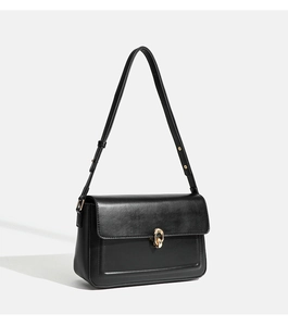 Detail of matte black leather shoulder bag with polished gold ring buckle closure