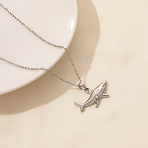Macro view of polished shark pendant with fine textures on stainless steel chain