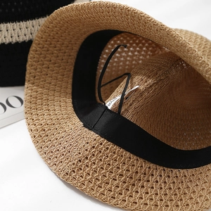 Detail shot of hollow-out straw sun hat featuring adjustable sweatband and fine weaving