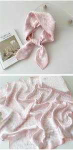 Detailed view of pink and white checkered silk scarf with smooth satin texture finish