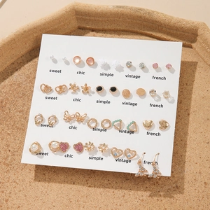 Detailed view of 20 pairs of pearl and rhinestone stud earrings on a display card