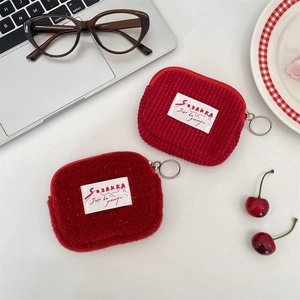Detail of red corduroy and lamb wool mini coin purses with metal zipper and woven label