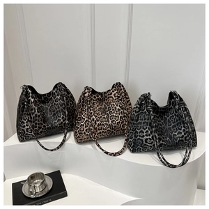 Three leopard print tote bags in brown, tan, and grey colors shown on white pedestals
