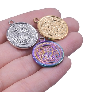 Macro detail of ancient owl pendants in silver, gold, and multicolor steel finishes