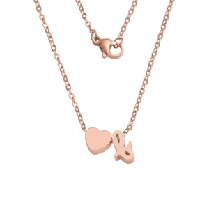 Detail of rose gold heart pendant with cursive letter charm on a thin link chain