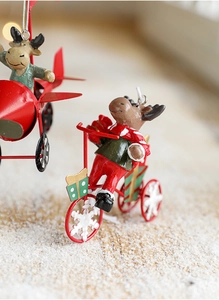 Macro shot of resin reindeer on a bicycle and plane Christmas ornaments with snowy texture