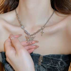 Detail of lava butterfly necklace with rhinestones and grey pearls on model's neckline