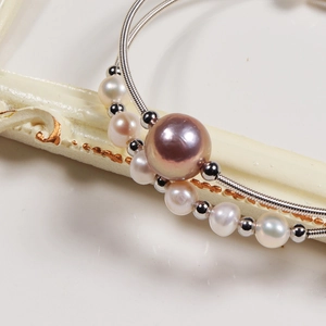 Macro shot of large purple freshwater pearl with white pearls on silver snake chain