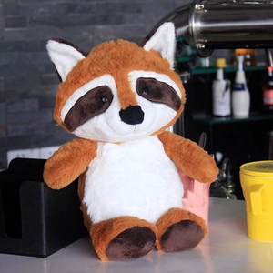 Cute raccoon plush toy doll sitting on a table in a cozy home kitchen setting