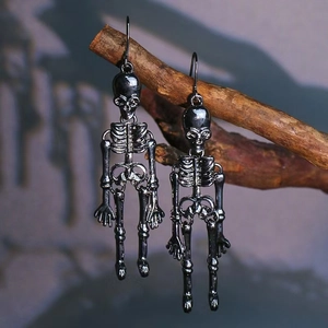 Gothic punk skeleton drop earrings in gunmetal finish hanging on dry wooden branches