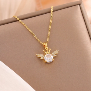 Elegant gold crown and angel wings necklace with clear zircon in a jewelry box